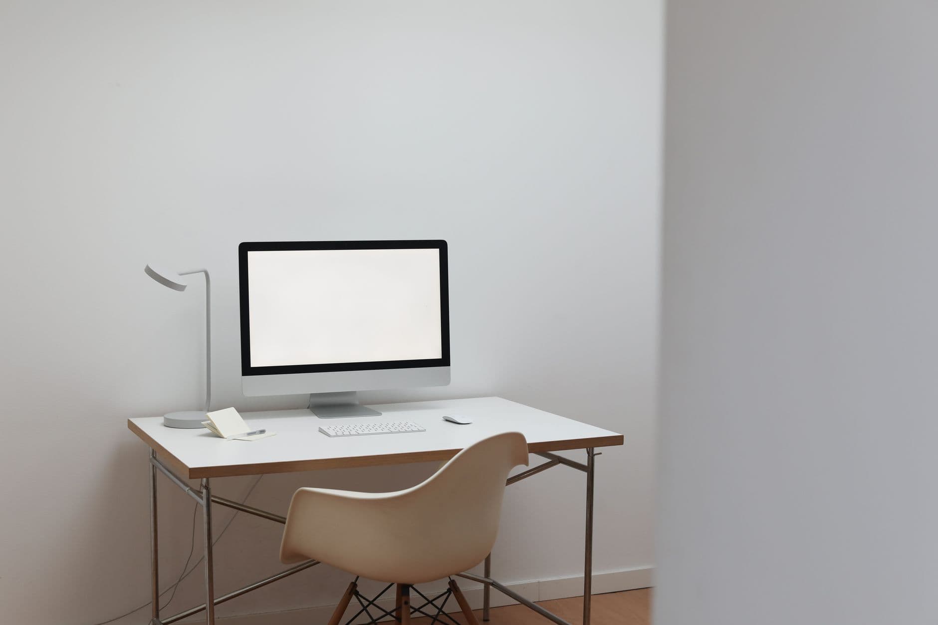 Interior of room in minimal design with modern computer on white table and comfortable chair